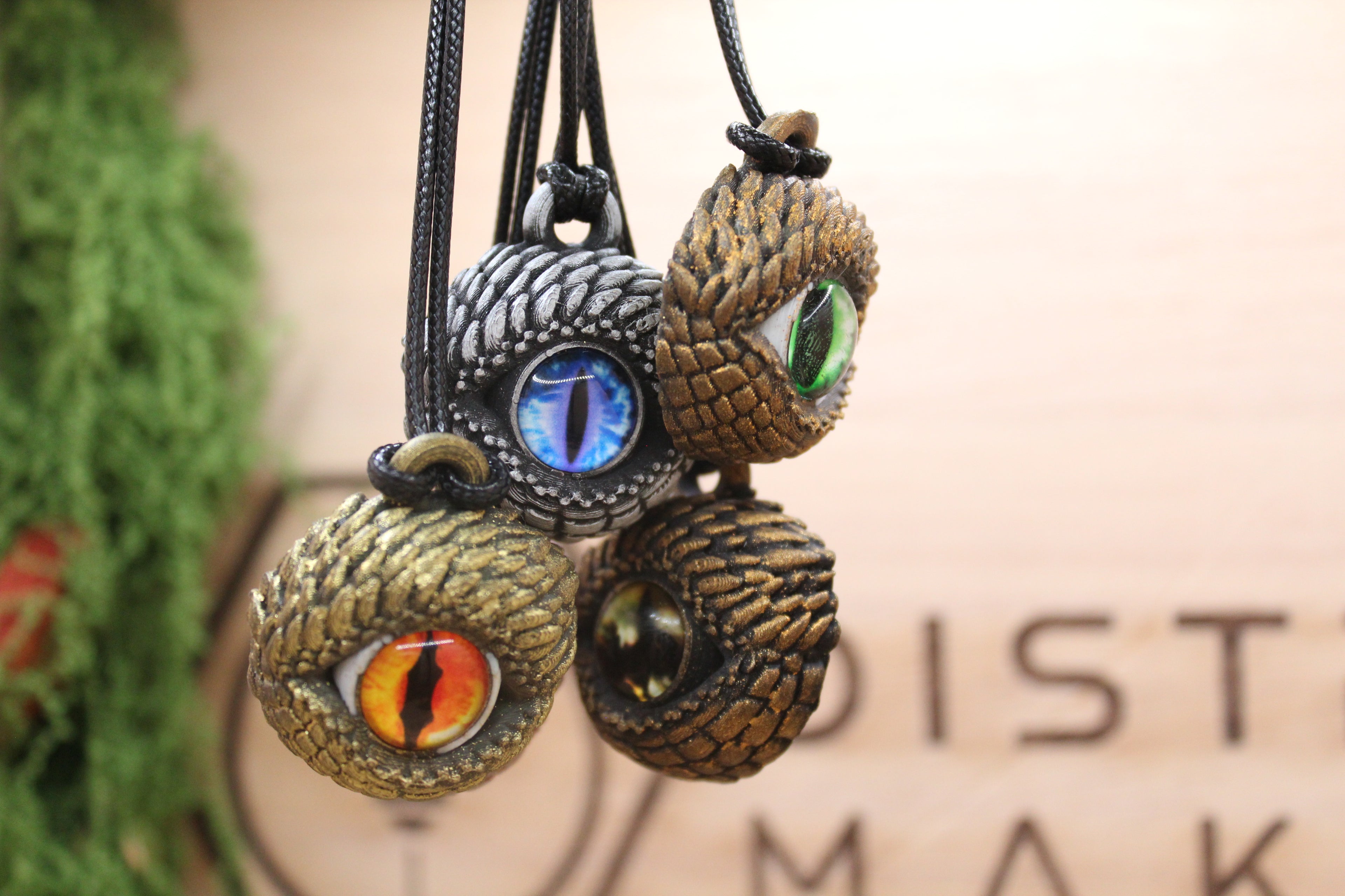 Cinco colgantes de ojo de Cuélebre artesanales sobre rodaja de madera, con iris en azul, rosa, verde, naranja y dorado — amuleto de protección, Distrito Makers