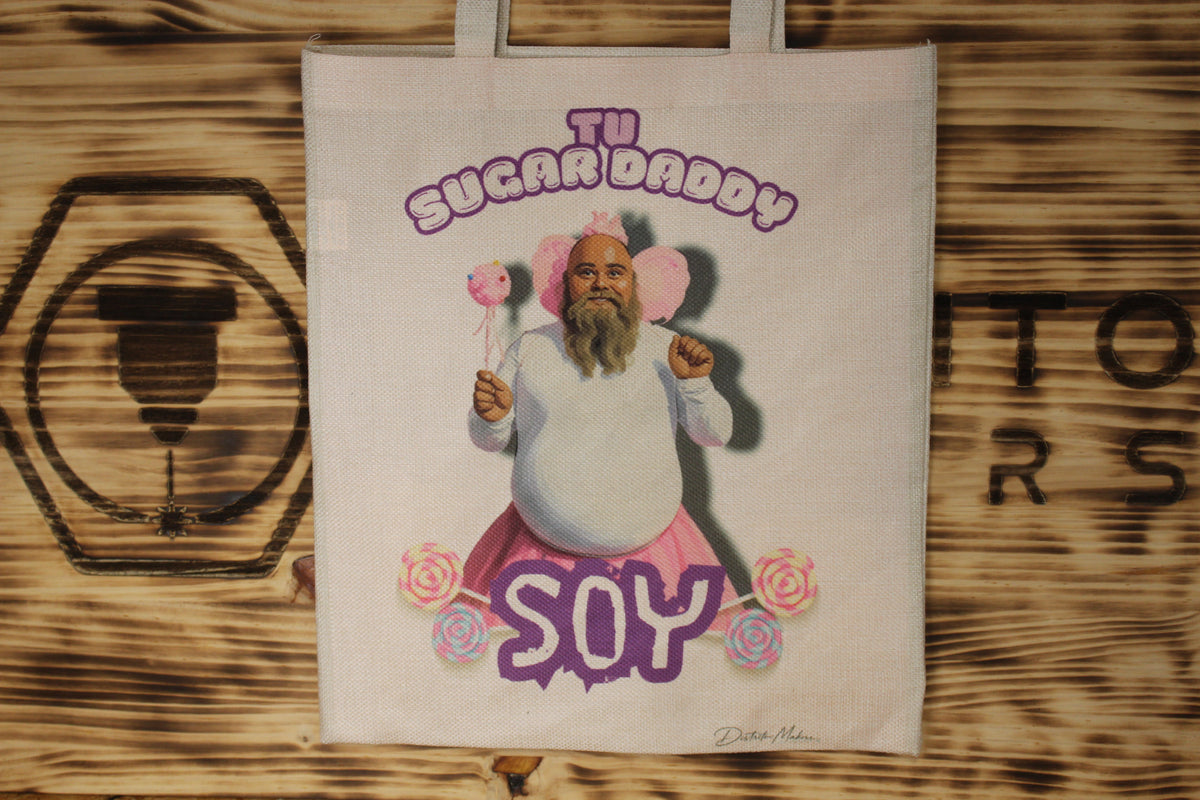 Tote bag de tela símil lino con el lema «Tu sugar daddy soy» y la ilustración de un hombre con barba, tutú rosa, alas de hada y piruletas