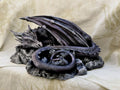 Soporte de móvil con forma de dragón plateado enroscado sobre una base de roca, impreso en 3D y pintado a mano — Distrito Makers