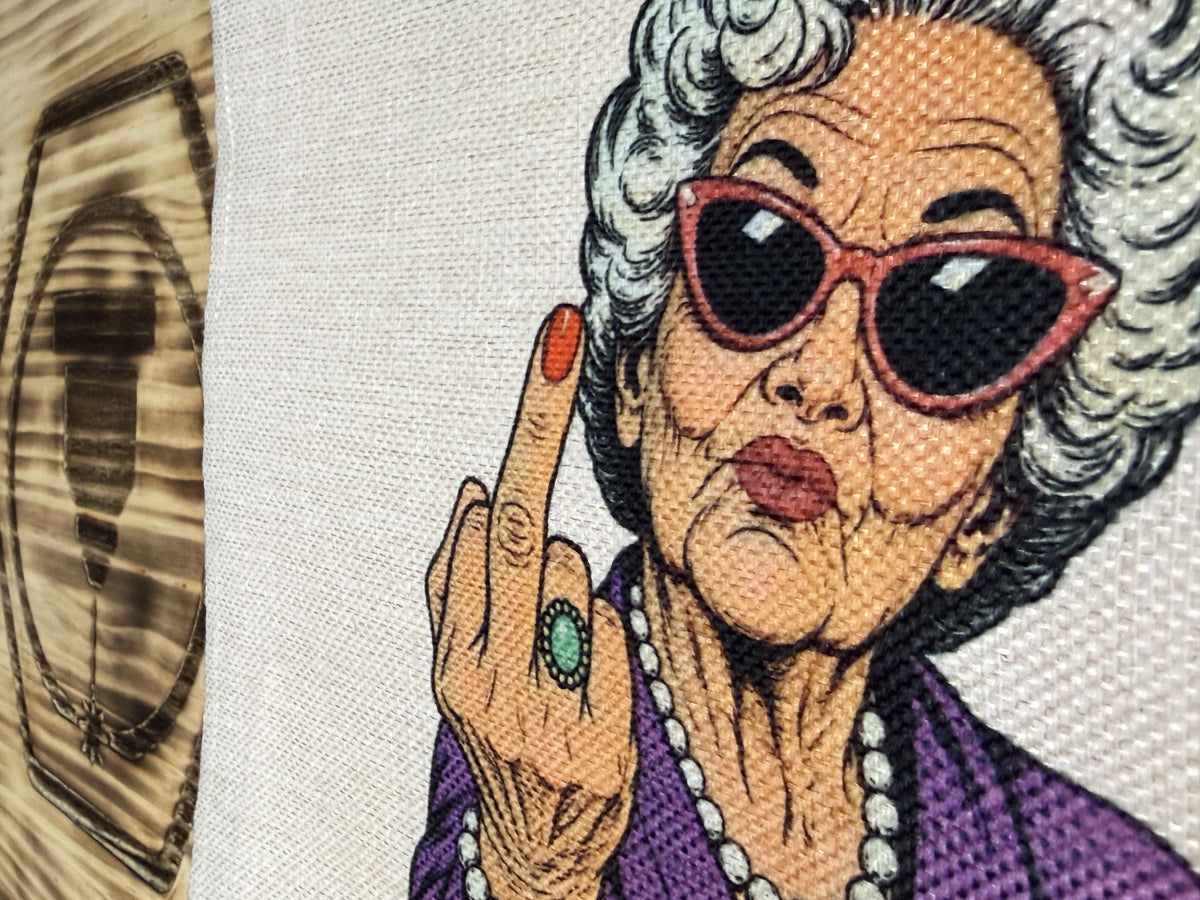 Detalle de la señora de pelo blanco y gafas de sol rojas estampada en la tote bag «Aquí llevo mis cosas de señora»