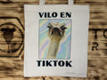 Tote bag de tela símil lino con el lema en asturiano «Vilo en TikTok» y la foto de un avestruz sobre fondo holográfico