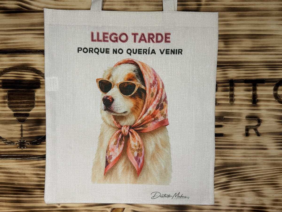 Tote bag de tela símil lino con el lema «Llego tarde porque no quería venir» y un perro con gafas de sol y pañuelo a la cabeza