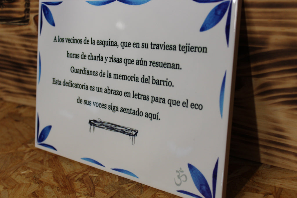 Detalle en ángulo del texto y el dibujo del banco en el azulejo personalizado de cenefa azul, con acabado brillo